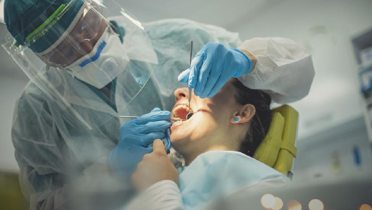 Dokter gigi memeriksa pasien
